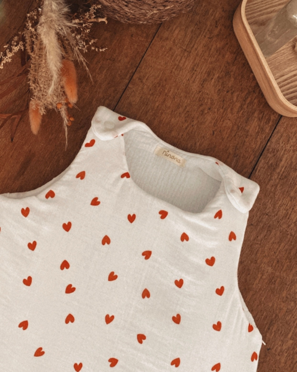 Découvrez la gigoteuse Ninona artisanale en coton double gaze, parsemée de cœurs rouges tendance. Faite main en France, elle garantit chaleur et douceur pour le sommeil de bébé. Un indispensable cocooning qui allie artisanat français et design actuel pour la chambre des futurs parents.