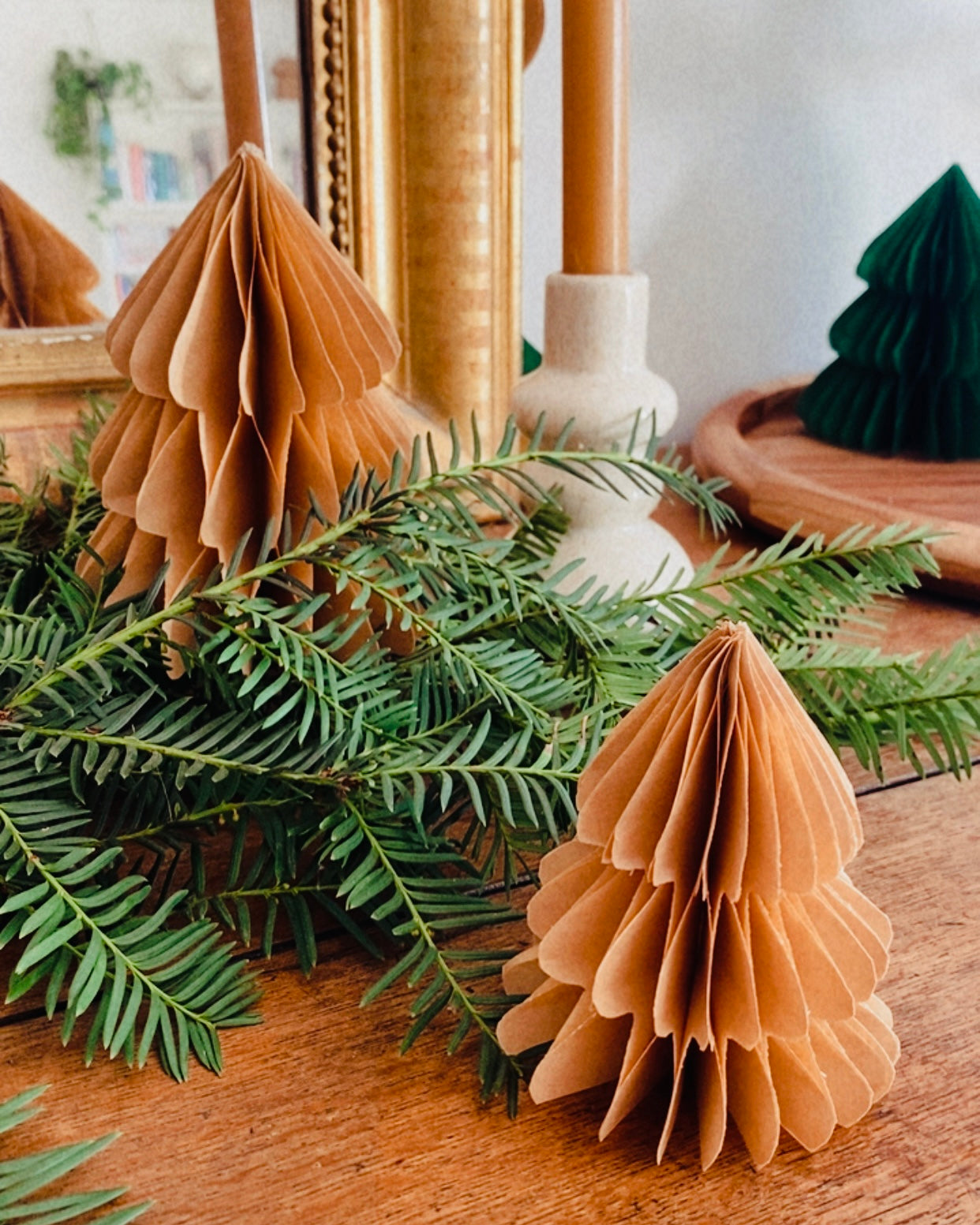 Petit sapin en papier fait main, présenté en décor de Noël naturel. Chaque pièce est unique, réalisée avec soin artisanal. Ces sapins décoratifs ajoutent une touche chaleureuse et poétique, idéale pour une décoration de table ou une ambiance douce et hivernale dans la maison. ninona