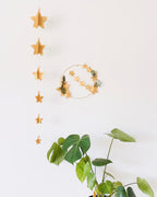 Détail de guirlande étoilée faite main : étoiles en papier en relief, perles en bois naturel, ficelle dorée. Décoration douce, minimaliste et aérienne. À suspendre au mur, au plafond ou à poser sur un meuble. Longueur d’environ 95 cm. Idéale pour une atmosphère de Noël, mais aussi pour ajouter une touche poétique au quotidien. Pièce artisanale française, réalisée avec soin et précision. ninona