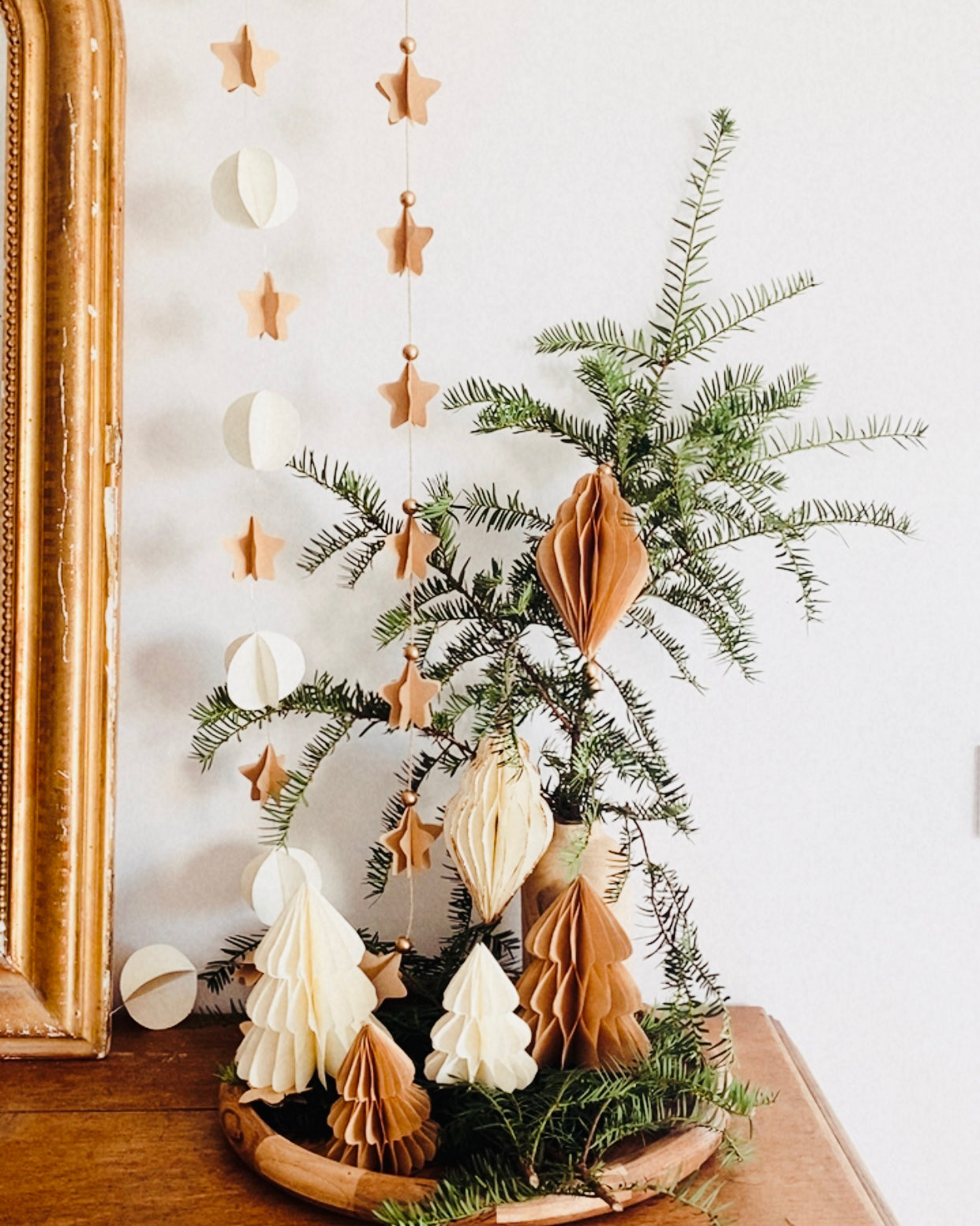 Petit sapin en papier fait main, présenté en décor de Noël naturel. Chaque pièce est unique, réalisée avec soin artisanal. Ces sapins décoratifs ajoutent une touche chaleureuse et poétique, idéale pour une décoration de table ou une ambiance douce et hivernale dans la maison. ninona