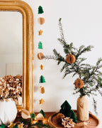 Guirlande de Noël artisanale décorée de sapins, étoiles et formes rondes en papier. La lumière LED met en valeur les détails délicats du travail manuel. Une idée de décoration chaleureuse, naturelle et raffinée, conçue pour illuminer la maison pendant les fêtes. ninona