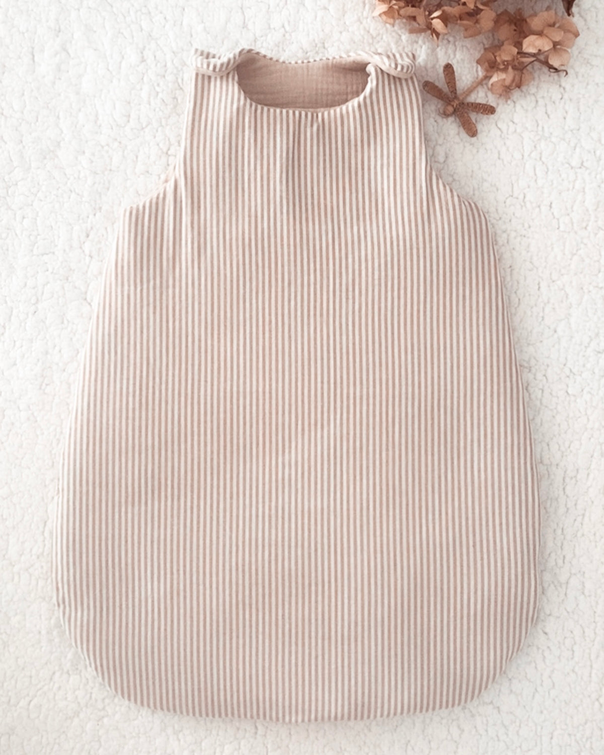 Gigoteuse bébé artisanale à rayures beige et écru, confectionnée avec soin à la main. Son style doux et intemporel s’accorde parfaitement à l’univers de bébé. Cette gigoteuse personnalisable peut être réalisée selon vos envies et convient aux filles comme aux garçons. Disponible en plusieurs tailles et en trois versions : été, mi-saison ou hiver, elle accompagne bébé au fil des saisons dans un cocon confortable et douillet. Idée cadeau de naissance originale et personnalisée. Ninona