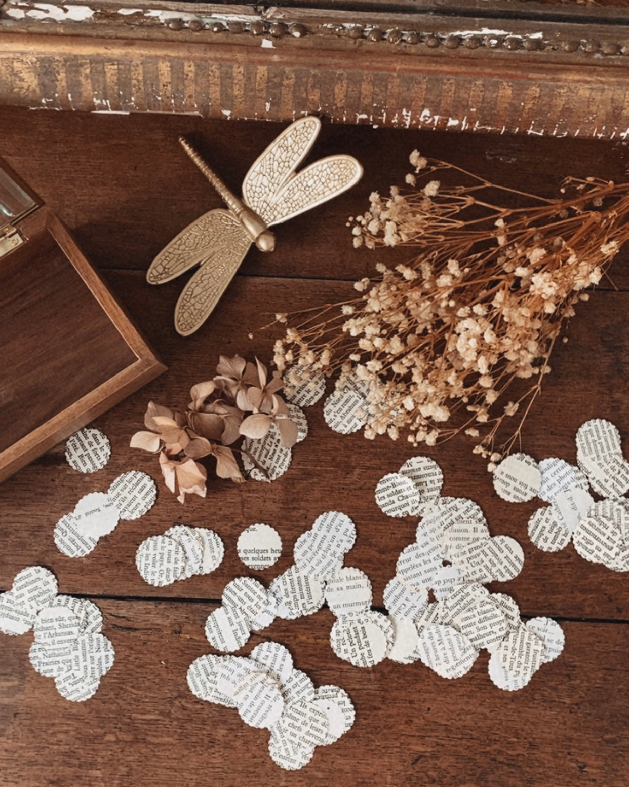 Confettis décoratifs découpés à partir de pages de vieux livres, présentés en grande quantité sur une surface claire. Chaque confetti est rond, en papier ancien légèrement jauni, avec des fragments de texte imprimé visibles. L’ensemble crée une ambiance vintage, poétique et artisanale. Ces confettis en papier recyclé sont idéals pour décorer une table de mariage, d’anniversaire ou de fête à thème bohème, littéraire ou champêtre. ninona création