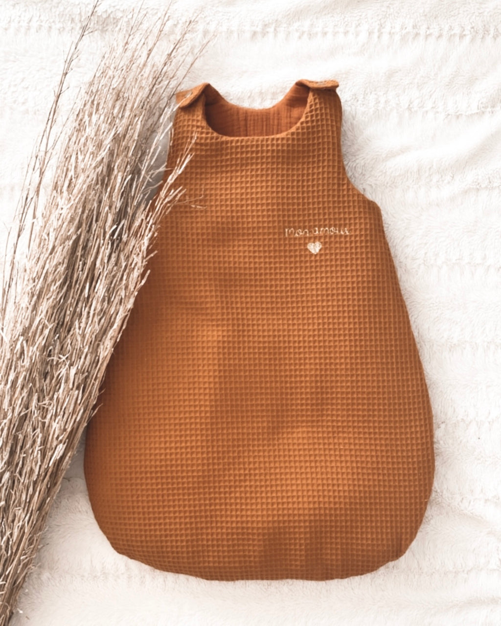 La gigoteuse bébé Ninona en nid d’abeille et double gaze de coton marron est idéale pour un sommeil sécurisé et confortable. Fabriquée à la main en France, cette gigoteuse personnalisée est un cadeau de naissance unique et raffiné. Ninona valorise l’artisanat français en créant des gigoteuses bébé douces, respirantes et personnalisables au prénom, parfaites pour accompagner les premiers mois de votre enfant.