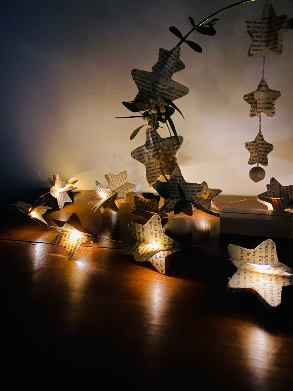 Guirlande de 2 mètres composée de 20 étoiles en papier 3D découpées dans des pages de vieux livres. La guirlande est légère et peut être suspendue sur un mur, une étagère, une tête de lit ou une branche décorative. Une décoration délicate, bohème et fait main qui crée une ambiance chaleureuse et naturelle. ninona