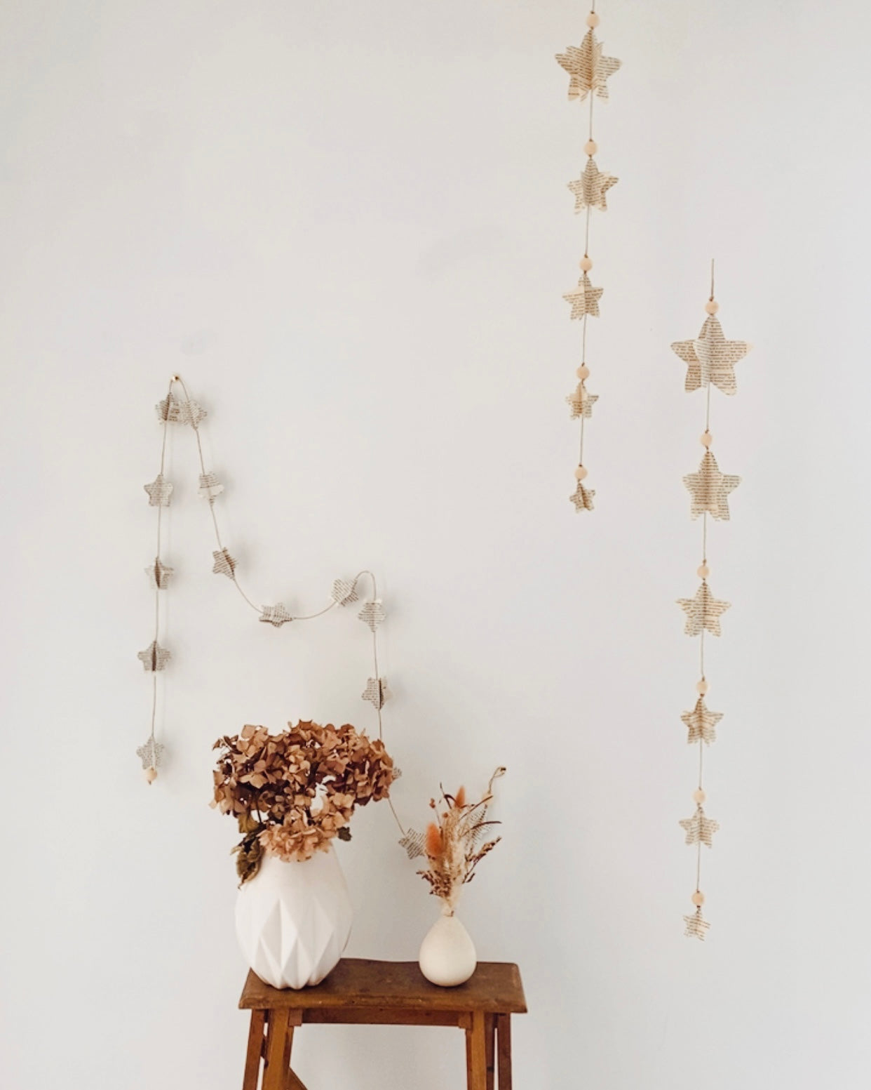 Sur un fil de jute, les étoiles en papier d’anciens livres s’égrènent comme un poème. Leurs reliefs captent la lumière et révèlent la beauté simple du fait main. Entre pages froissées et perles de bois, cette guirlande de 185 cm apporte chaleur et authenticité à chaque coin de maison. Une ode à la douceur et au temps retrouvé. ninona