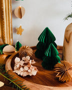 Lot de deux sapins en papier faits main, en vert émeraude, posés sur un plateau en bois dans une ambiance douce et chaleureuse. Ces décorations artisanales de Noël apportent une touche poétique et naturelle à votre intérieur. Idéal pour compléter une décoration de table, créer un village d’hiver miniature ou offrir un cadeau fait avec soin. ninona