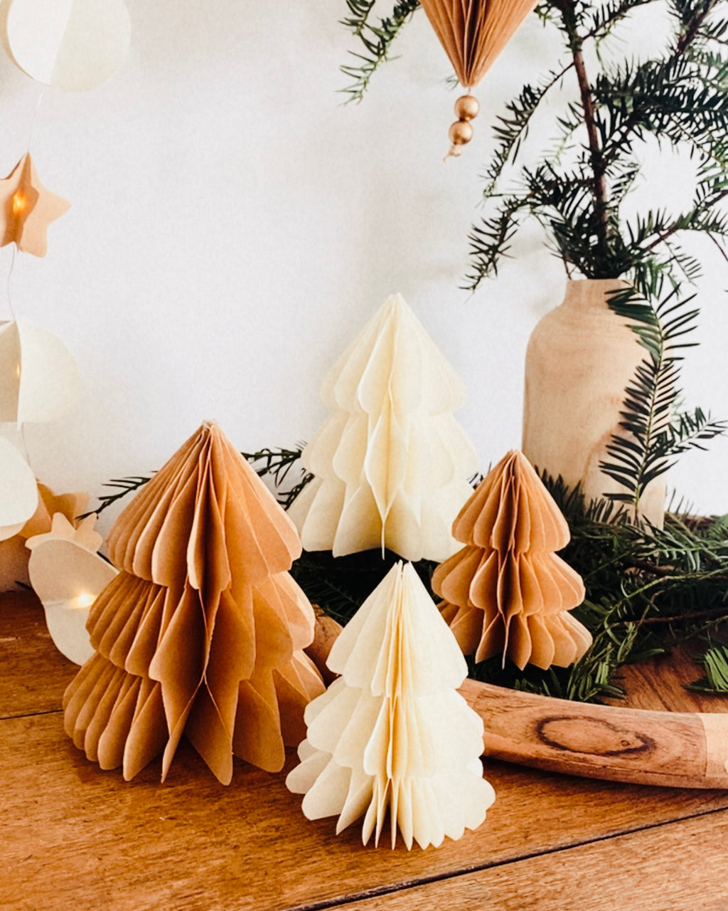Petit sapin en papier fait main, présenté en décor de Noël naturel. Chaque pièce est unique, réalisée avec soin artisanal. Ces sapins décoratifs ajoutent une touche chaleureuse et poétique, idéale pour une décoration de table ou une ambiance douce et hivernale dans la maison. ninona
