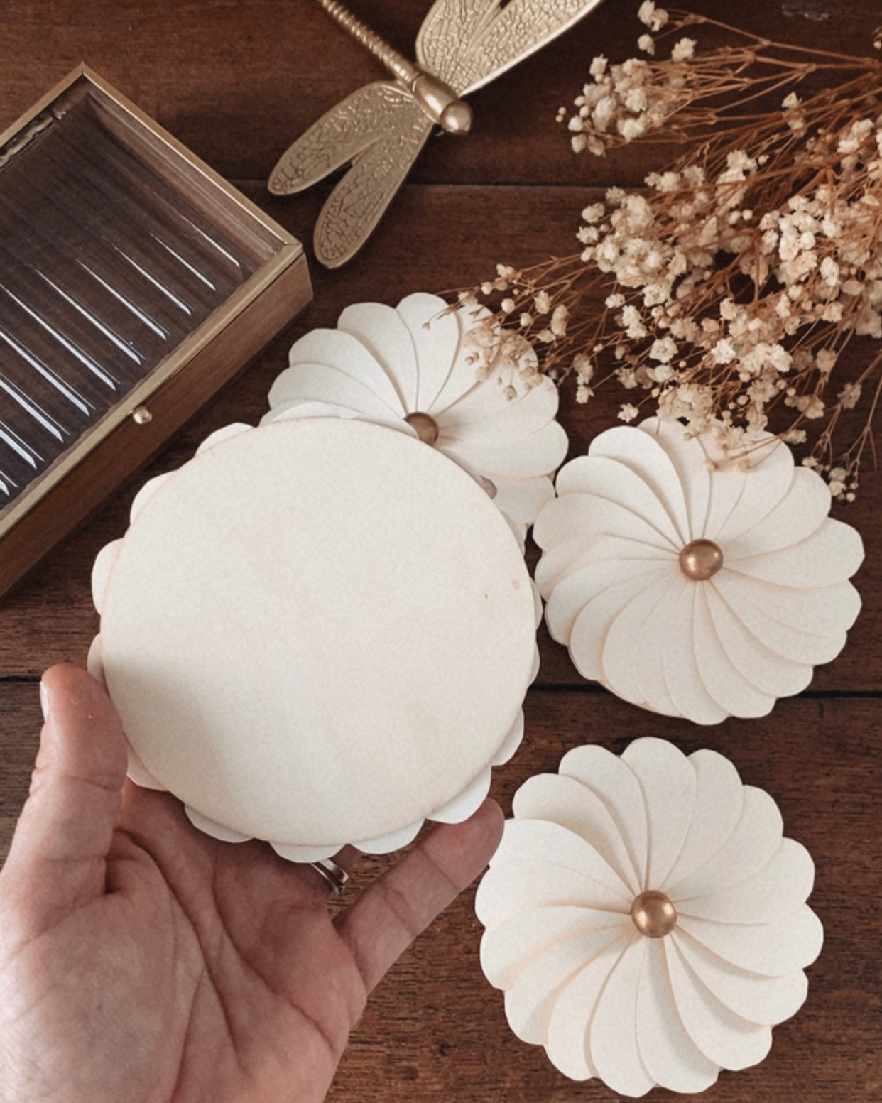 Vue arrière d’une fleur en papier écru faite main, montrant la structure soignée et le montage des pétales sur leur support. Cette image met en évidence la qualité artisanale et la simplicité du design, pensé pour une utilisation en décoration murale ou de table. La fleur s’intègre harmonieusement dans une décoration bohème, scandinave ou naturelle, pour un mariage, une réception ou un espace de vie apaisant. ninona creation