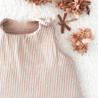 Gigoteuse bébé artisanale à rayures beige et écru, confectionnée avec soin à la main. Son style doux et intemporel s’accorde parfaitement à l’univers de bébé. Cette gigoteuse personnalisable peut être réalisée selon vos envies et convient aux filles comme aux garçons. Disponible en plusieurs tailles et en trois versions : été, mi-saison ou hiver, elle accompagne bébé au fil des saisons dans un cocon confortable et douillet. Idée cadeau de naissance originale et personnalisée. Ninona