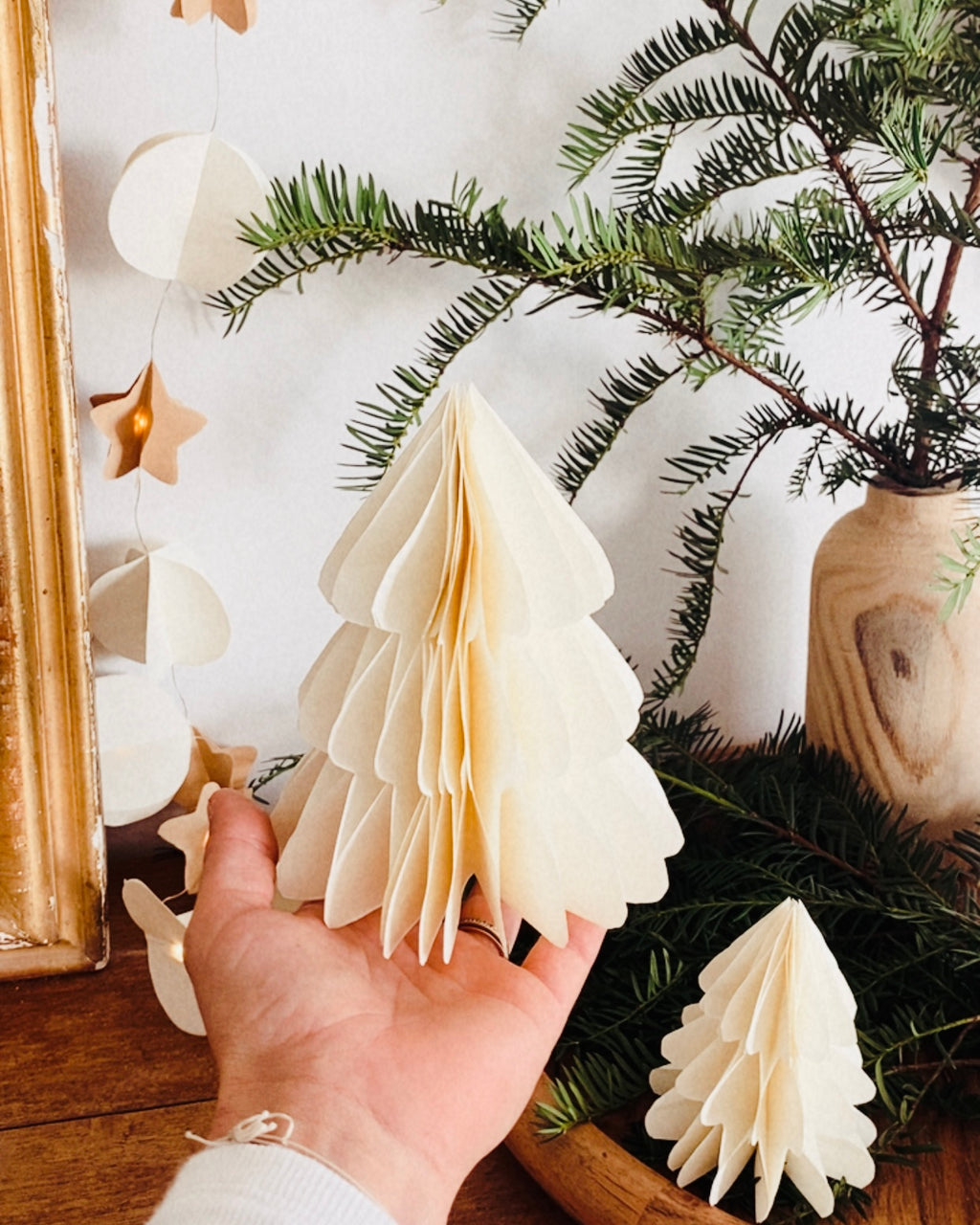 Petit sapin en papier fait main, présenté en décor de Noël naturel. Chaque pièce est unique, réalisée avec soin artisanal. Ces sapins décoratifs ajoutent une touche chaleureuse et poétique, idéale pour une décoration de table ou une ambiance douce et hivernale dans la maison. ninona