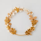Couronne décorative artisanale en papier, réalisée à la main avec un assemblage délicat de feuilles et fleurs aux tons naturels. Cette création poétique et légère apporte une touche chaleureuse à une chambre, un salon ou un espace événementiel. Idéale en cadeau unique ou comme décoration murale personnalisable. Fabrication soignée, pièce unique au style minimaliste et naturel. ninona
