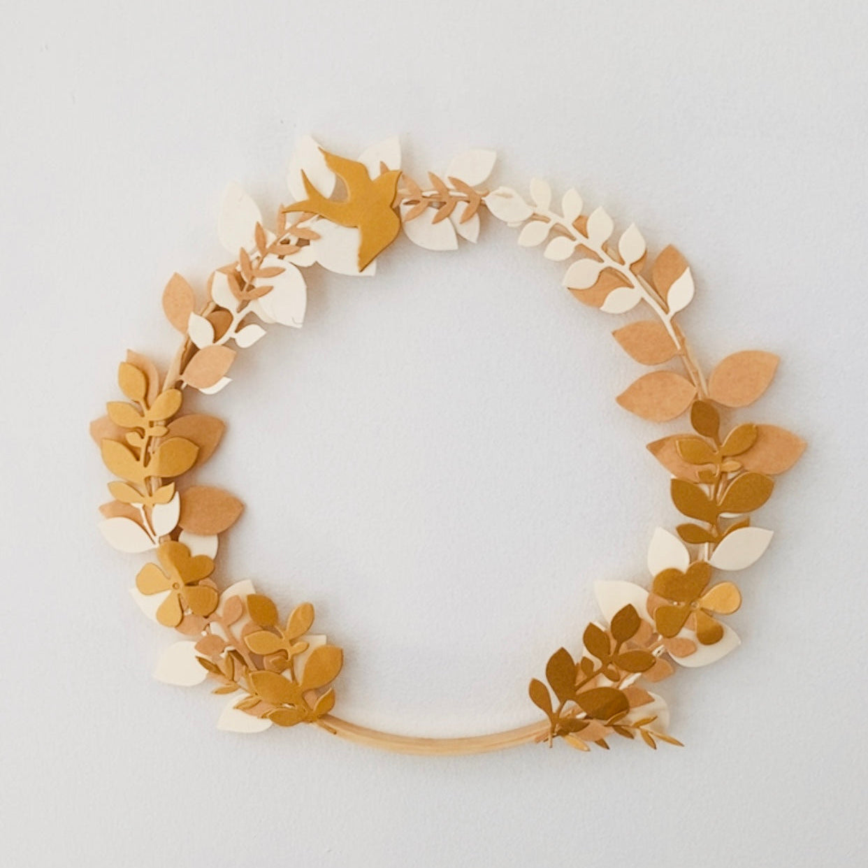Couronne décorative artisanale en papier, réalisée à la main avec un assemblage délicat de feuilles et fleurs aux tons naturels. Cette création poétique et légère apporte une touche chaleureuse à une chambre, un salon ou un espace événementiel. Idéale en cadeau unique ou comme décoration murale personnalisable. Fabrication soignée, pièce unique au style minimaliste et naturel. ninona