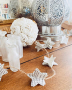 Des mots oubliés se transforment en étoiles. Façonnées dans des pages jaunies, ces petites créations prennent vie sur un fil de jute, reliées par des perles de bois. Longue de 185 cm, cette guirlande évoque le murmure d’un livre qu’on aurait laissé ouvert au vent. Une décoration délicate, simple et poétique, qui invite à la rêverie et au souvenir. ninona