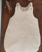 Gigoteuse d’hiver en sherpa et double gaze de coton pour bébé, coloris écru naturel avec petits cœurs beige. Confortable, chaude et respirante, elle offre un cocon douillet idéal pour les nuits hivernales. Fermeture pratique par pressions aux épaules. Parfaite comme cadeau de naissance ou pour assurer des nuits paisibles à bébé tout en douceur. Style bohème, matières naturelles et moelleuses
