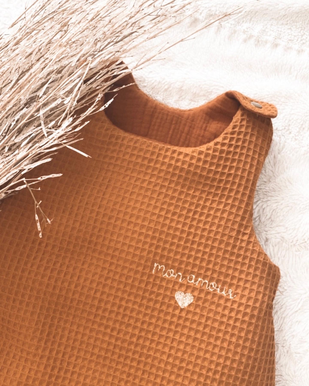 La gigoteuse bébé Ninona en nid d’abeille et double gaze de coton marron est idéale pour un sommeil sécurisé et confortable. Fabriquée à la main en France, cette gigoteuse personnalisée est un cadeau de naissance unique et raffiné. Ninona valorise l’artisanat français en créant des gigoteuses bébé douces, respirantes et personnalisables au prénom, parfaites pour accompagner les premiers mois de votre enfant.