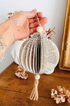 Cette boule en papier recyclé est une création artisanale unique, issue de pages de vieux livres. Sa texture vintage et ses détails naturels en font une décoration durable et raffinée. Parfaite pour suspendre ou poser, elle apporte une touche poétique et éthique à votre décoration d’intérieur. Fait main avec amour dans une démarche éco-responsable. ninona