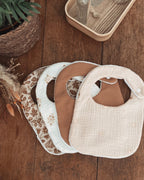 Lot artisanal de bavoirs bébé faits main en coton, gaze de coton et tissu absorbant. Chaque bavoir est doux, pratique et confortable pour la peau délicate de bébé. Fermeture par bouton pression sécurisée, idéale dès la naissance. Motifs assortis aux tons naturels et floraux bohèmes. Un lot de bavoirs élégants et absorbants, parfaits pour les repas ou les bavouilles quotidiennes. Accessoire pratique et esthétique, idéal comme cadeau de naissance ou baby shower