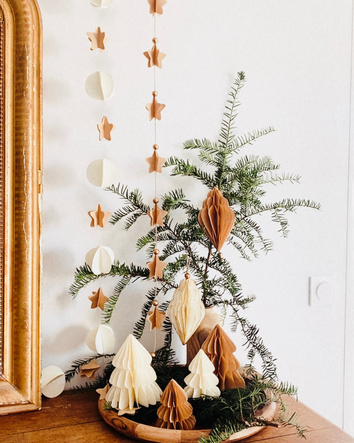 Petit sapin en papier fait main, présenté en décor de Noël naturel. Chaque pièce est unique, réalisée avec soin artisanal. Ces sapins décoratifs ajoutent une touche chaleureuse et poétique, idéale pour une décoration de table ou une ambiance douce et hivernale dans la maison. ninona