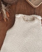 Gigoteuse d’hiver en sherpa et double gaze de coton pour bébé, coloris écru naturel avec petits cœurs beige. Confortable, chaude et respirante, elle offre un cocon douillet idéal pour les nuits hivernales. Fermeture pratique par pressions aux épaules. Parfaite comme cadeau de naissance ou pour assurer des nuits paisibles à bébé tout en douceur. Style bohème, matières naturelles et moelleuses