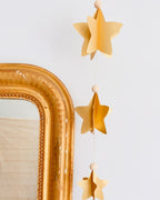 Guirlande longue d’environ 95 cm composée de six étoiles en volume 3D, montées sur une ficelle dorée avec des perles en bois. Décoration artisanale douce et élégante, réalisée à la main en France. Convient pour suspendre au mur, encadrer un miroir, décorer une fête ou embellir un intérieur tout au long de l’année. Style chaleureux, minimaliste et naturel. ninona