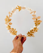 Couronne en papier réalisée à la main, mêlant feuilles, fleurs et couleurs douces pour une décoration murale délicate. Sa structure légère en bois et son style naturel en font un objet parfait pour un intérieur minimaliste, un événement ou un cadeau unique. Chaque pièce est fabriquée entièrement à la main, offrant une création raffinée, poétique et personnalisable selon vos envies. ninona