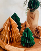 Petit sapin en papier fait main, présenté en décor de Noël naturel. Chaque pièce est unique, réalisée avec soin artisanal. Ces sapins décoratifs ajoutent une touche chaleureuse et poétique, idéale pour une décoration de table ou une ambiance douce et hivernale dans la maison. ninona