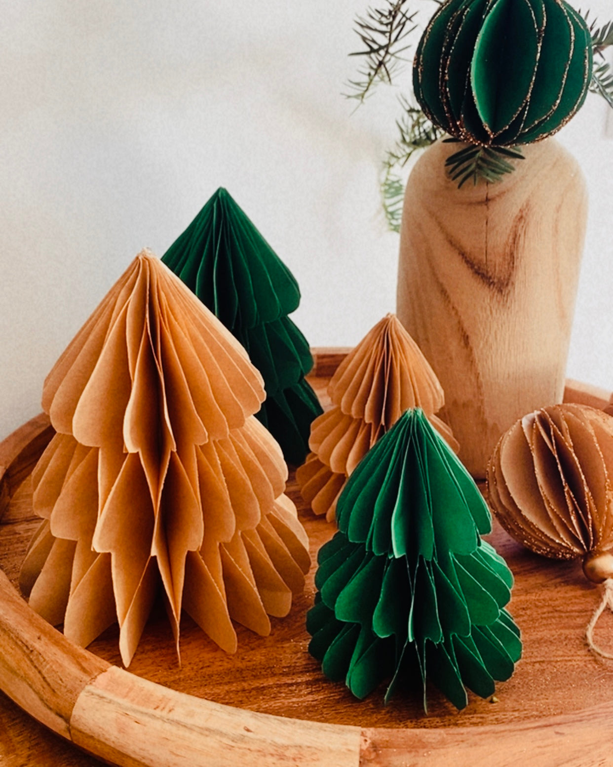 Petit sapin en papier fait main, présenté en décor de Noël naturel. Chaque pièce est unique, réalisée avec soin artisanal. Ces sapins décoratifs ajoutent une touche chaleureuse et poétique, idéale pour une décoration de table ou une ambiance douce et hivernale dans la maison. ninona