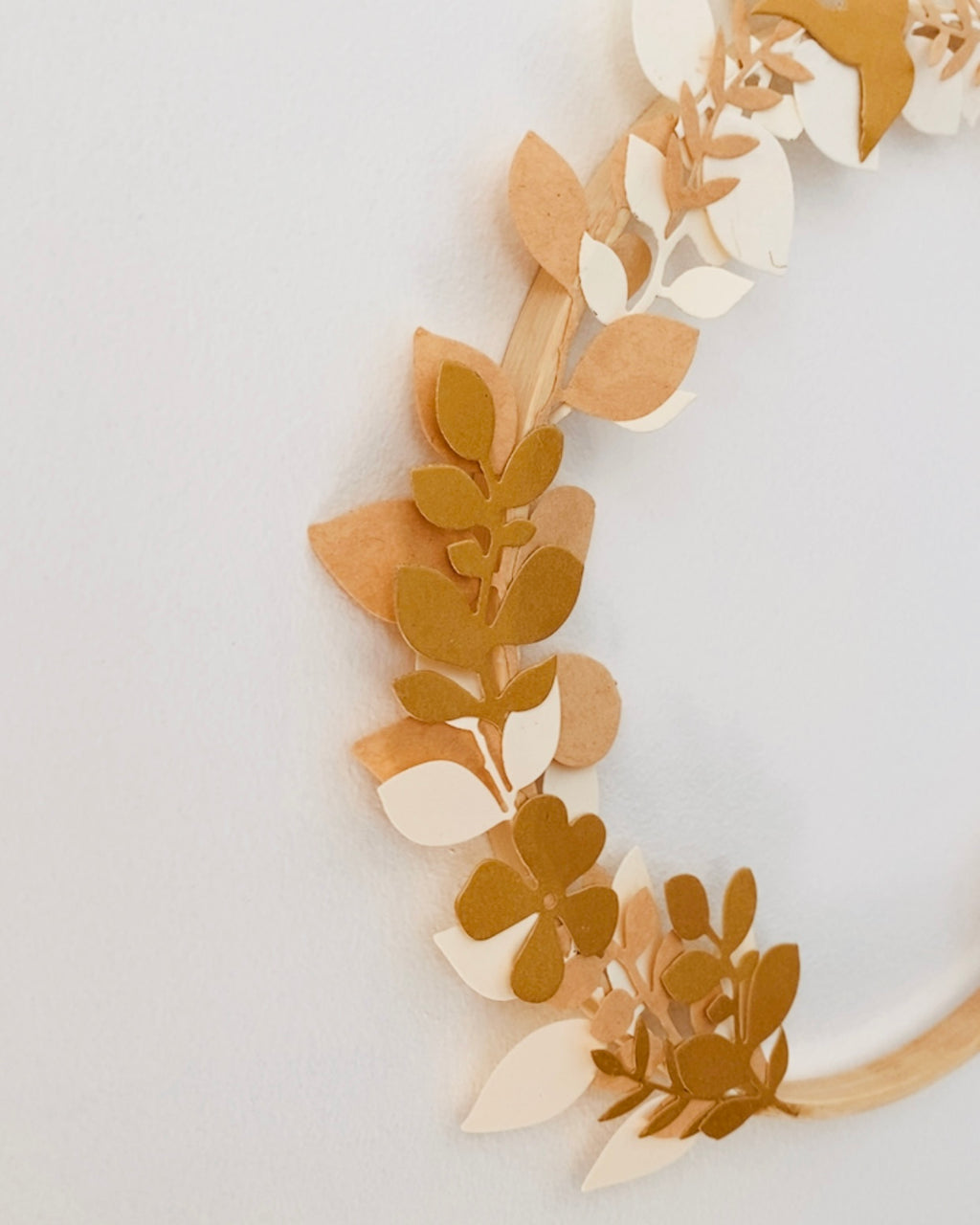 Couronne murale faite main, composée de feuillages en papier découpés un à un et fixés sur un cercle en bois. Son design naturel et épuré en fait une décoration idéale pour une chambre d’enfant, un coin lecture ou un intérieur chaleureux. Légère, durable et personnalisable, cette création artisanale est parfaite pour un cadeau original ou une touche décorative douce et moderne. ninona
