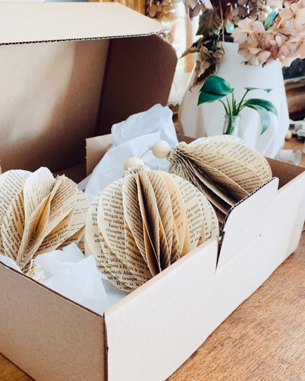 Sensible au fait main et à la décoration durable ? Cette boule de Noël en papier recyclé est conçue artisanalement à partir de livres anciens. L’upcycling permet de leur offrir une seconde vie décorative pleine d’âme. Ses touches de bois et de jute soulignent une esthétique naturelle et élégante. Une décoration éco-responsable pour un Noël chaleureux et raffiné. ninona