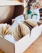 Sensible au fait main et à la décoration durable ? Cette boule de Noël en papier recyclé est conçue artisanalement à partir de livres anciens. L’upcycling permet de leur offrir une seconde vie décorative pleine d’âme. Ses touches de bois et de jute soulignent une esthétique naturelle et élégante. Une décoration éco-responsable pour un Noël chaleureux et raffiné. ninona