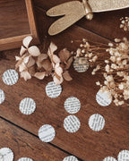Confettis en pages de livres vintage disposés sur une surface décorative, évoquant une table de réception ou une mise en scène festive. Le papier ancien et les textes imprimés créent une atmosphère romantique, douce et littéraire. Ces confettis sont parfaits pour une décoration de mariage bohème, une fête élégante ou un événement à thème vintage, tout en respectant une démarche éco-responsable. ninona création