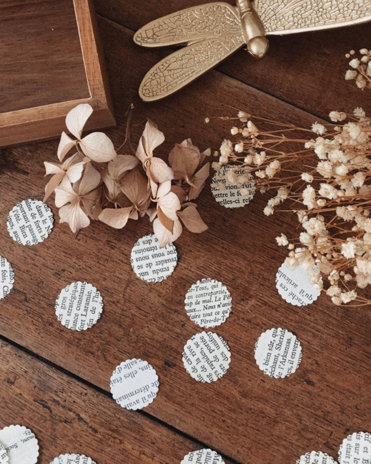 Confettis en pages de livres vintage disposés sur une surface décorative, évoquant une table de réception ou une mise en scène festive. Le papier ancien et les textes imprimés créent une atmosphère romantique, douce et littéraire. Ces confettis sont parfaits pour une décoration de mariage bohème, une fête élégante ou un événement à thème vintage, tout en respectant une démarche éco-responsable. ninona création