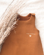 La gigoteuse bébé Ninona en nid d’abeille et double gaze de coton marron est idéale pour un sommeil sécurisé et confortable. Fabriquée à la main en France, cette gigoteuse personnalisée est un cadeau de naissance unique et raffiné. Ninona valorise l’artisanat français en créant des gigoteuses bébé douces, respirantes et personnalisables au prénom, parfaites pour accompagner les premiers mois de votre enfant.