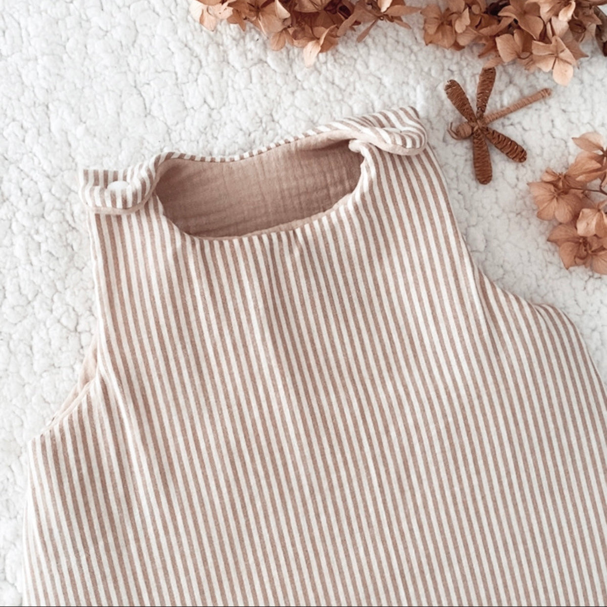 Gigoteuse bébé artisanale à rayures beige et écru, confectionnée avec soin à la main. Son style doux et intemporel s’accorde parfaitement à l’univers de bébé. Cette gigoteuse personnalisable peut être réalisée selon vos envies et convient aux filles comme aux garçons. Disponible en plusieurs tailles et en trois versions : été, mi-saison ou hiver, elle accompagne bébé au fil des saisons dans un cocon confortable et douillet. Idée cadeau de naissance originale et personnalisée. Ninona