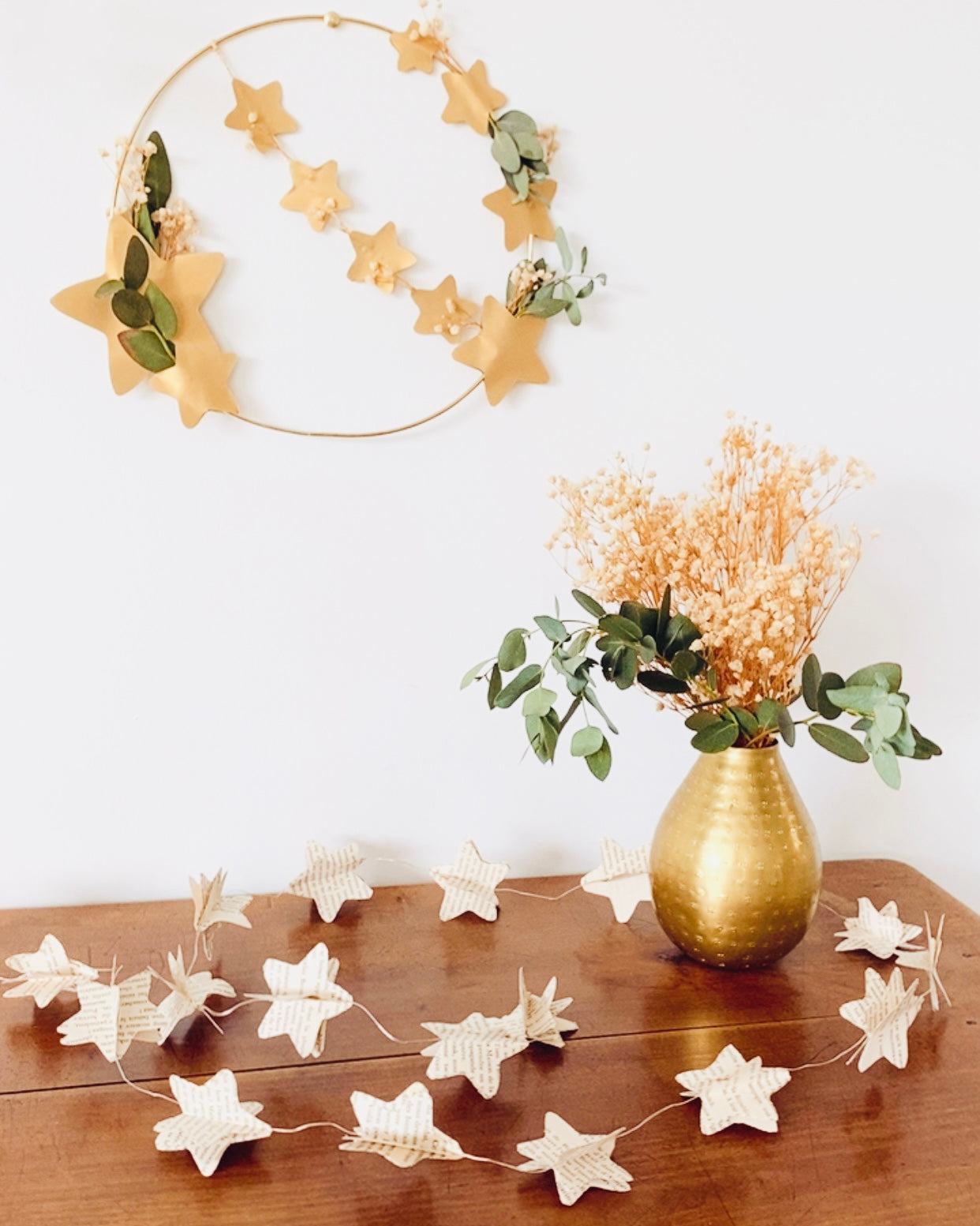 Vue détaillée de la guirlande lumineuse étoiles en papier de livres anciens. Les étoiles sont assemblées à la main et montées sur une guirlande LED à lumière chaude. La texture du papier et le relief donnent un aspect artisanal et poétique. Une décoration éco-responsable qui apporte douceur et charme à une pièce, parfaite pour une chambre ou un coin lecture. ninona
