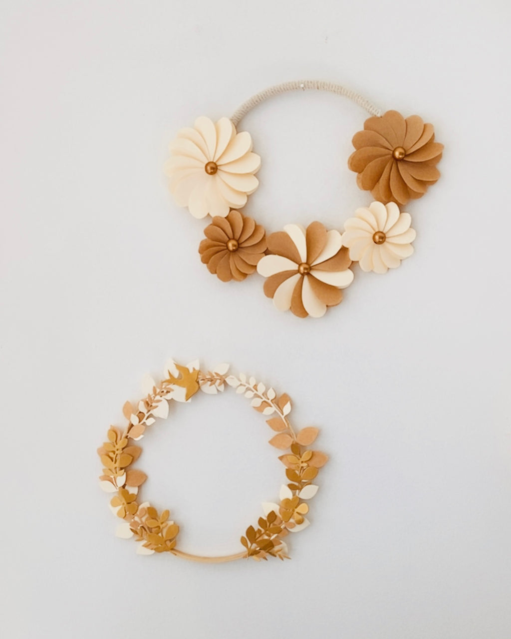 Couronne décorative artisanale composée de feuillages en papier soigneusement découpés et assemblés. Idéale pour décorer un mur, une chambre d’enfant ou offrir un cadeau original. Son style naturel et ses nuances chaleureuses apportent douceur et élégance à tout intérieur. Chaque couronne est une pièce unique, réalisée à la main avec précision, et personnalisable sur demande. ninona