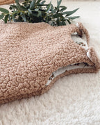 Détail du sherpa chocolat de cette gigoteuse bébé hiver 0/6 mois, avec sa texture douce, moelleuse et chaleureuse. On aperçoit également la double gaze de coton blanc cassé imprimée de motifs végétaux naturels, ainsi que les finitions délicates de la turbulette. Cette création artisanale TOG 2 est conçue pour envelopper bébé dans un cocon confortable pendant les nuits fraîches. Une pièce intemporelle, douce et poétique, idéale pour une naissance en automne ou en hiver. Une création pour bébé. Ninona
