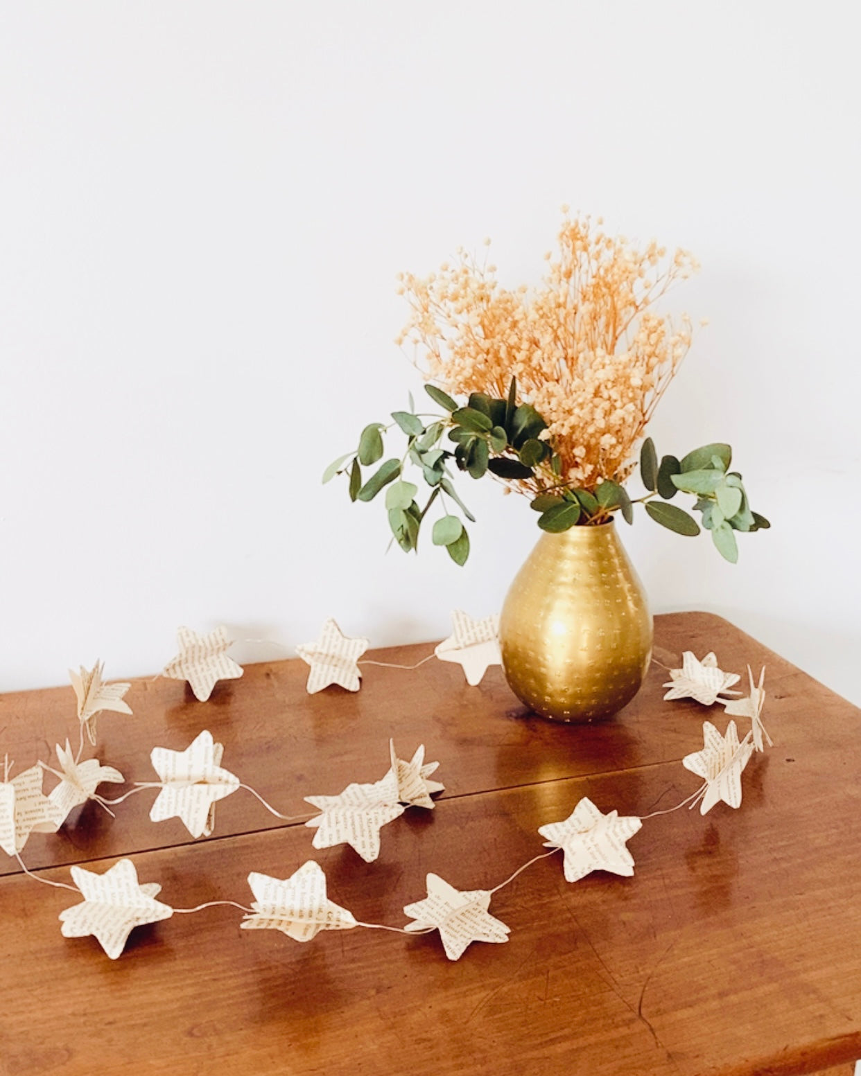 Guirlande allumée dans une ambiance douce. Les LED diffusent une lumière chaude qui met en valeur les étoiles en papier. Parfaite pour un coin détente, une chambre d’enfant, une atmosphère de lecture du soir ou un décor de fête intime. Objet décoratif artisanal et chaleureux. ninona