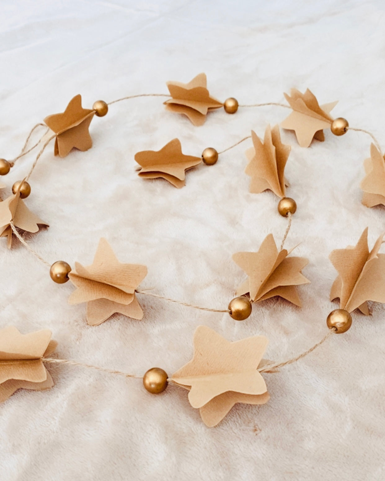 Décoration murale de Noël artisanale composée d’étoiles en papier découpées et superposées une à une. Parfaite pour créer une ambiance douce et poétique dans la maison : salon, entrée, chambre d’enfant, autour du sapin ou le long d’un miroir. Une guirlande minimaliste, légère, unique et fabriquée avec soin, qui apporte une touche naturelle et chaleureuse à l’univers festif. ninona