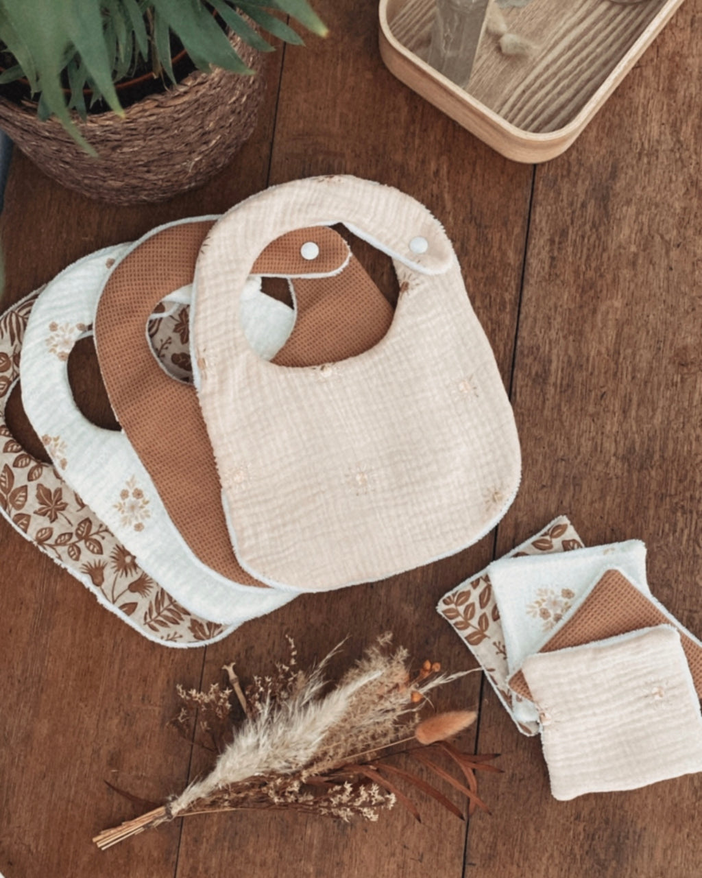 Lot artisanal de bavoirs personnalisables bébé faits main en coton, gaze de coton et tissu absorbant. Chaque bavoir est doux, pratique et confortable pour la peau délicate de bébé. Fermeture par bouton pression sécurisée, idéale dès la naissance. Motifs assortis aux tons naturels et floraux bohèmes. Un lot de bavoirs élégants et absorbants, parfaits pour les repas ou les bavouilles quotidiennes. Accessoire pratique et esthétique, idéal comme cadeau de naissance ou baby shower. Creation originale Ninona