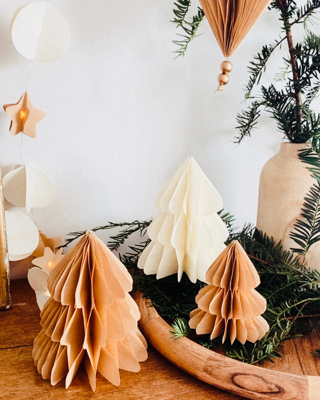 Petit sapin en papier fait main, présenté en décor de Noël naturel. Chaque pièce est unique, réalisée avec soin artisanal. Ces sapins décoratifs ajoutent une touche chaleureuse et poétique, idéale pour une décoration de table ou une ambiance douce et hivernale dans la maison. ninona