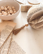 Cette boule de Noël est réalisée en upcycling à partir de pages de vieux livres. Façonnée à la main avec du papier recyclé, de la ficelle naturelle et des perles de bois, elle apporte une touche poétique et durable à votre décoration. Une pièce artisanale unique pour un Noël chaleureux, authentique et éco-responsable, à suspendre au sapin ou à intégrer dans une ambiance naturelle. ninona