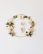 Couronne décorative artisanale réalisée à la main avec des pages de vieux livres découpées en forme d’étoiles, associées à de l’eucalyptus séché et de la gypsophile. Cette création poétique peut être suspendue ou posée, pour une décoration naturelle et chaleureuse. Idéale pour une décoration de Noël douce et lumineuse ou pour agrémenter la maison toute l’année. Une pièce d’artisanat français unique, bohème et pleine de charme, faite avec soin. ninona