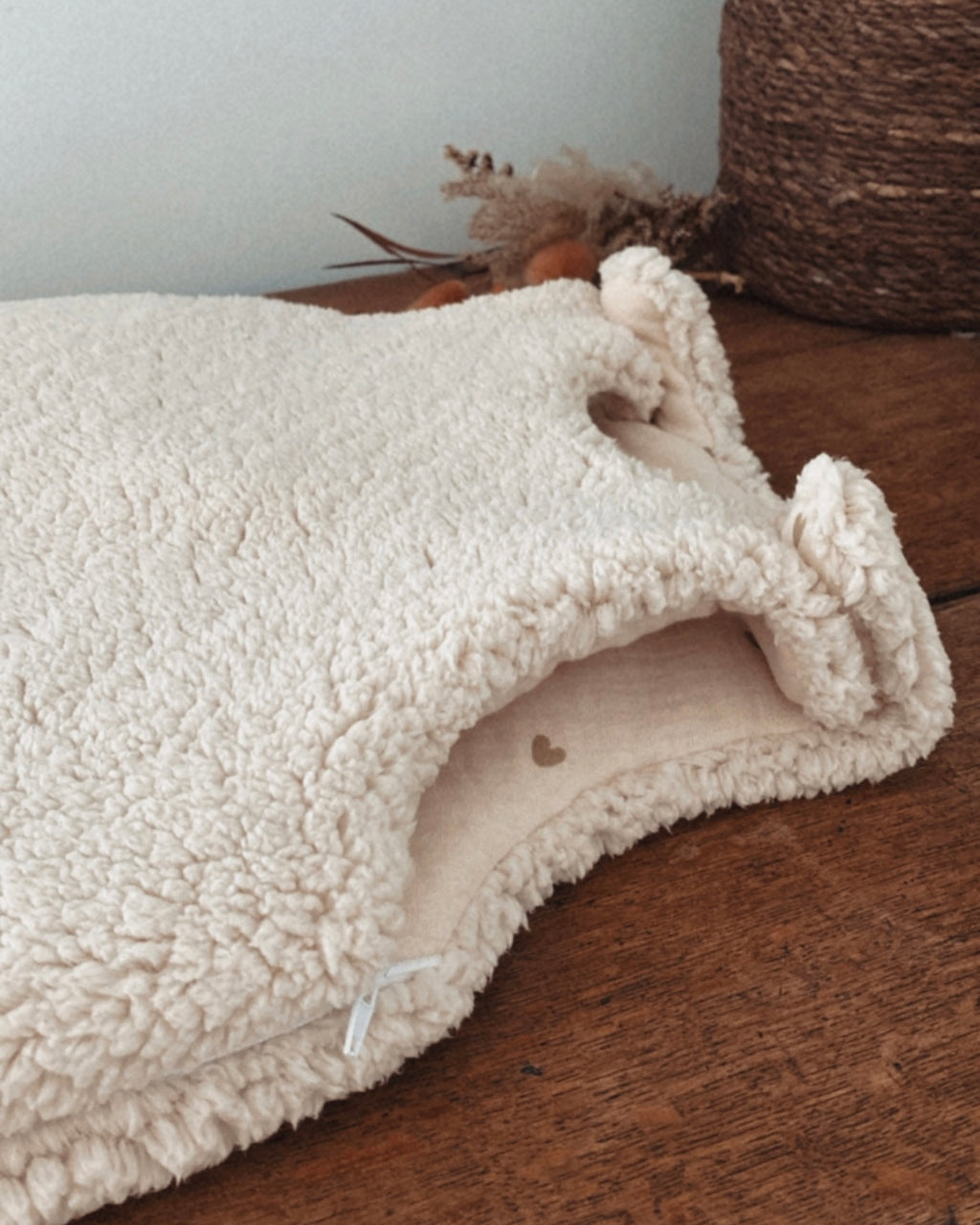 Gigoteuse d’hiver en sherpa et double gaze de coton pour bébé, coloris écru naturel avec petits cœurs beige. Confortable, chaude et respirante, elle offre un cocon douillet idéal pour les nuits hivernales. Fermeture pratique par pressions aux épaules. Parfaite comme cadeau de naissance ou pour assurer des nuits paisibles à bébé tout en douceur. Style bohème, matières naturelles et moelleuses
