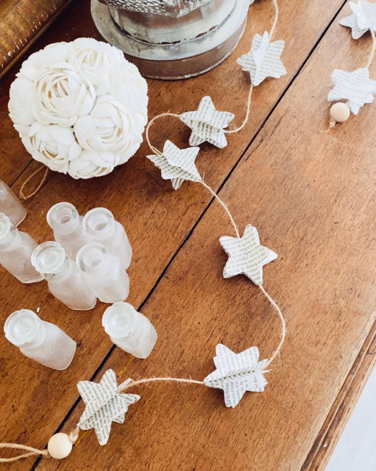 Chaque étoile porte une histoire. Découpée dans les pages d’un livre ancien, elle garde en elle la trace des mots et du temps. Ensemble, elles forment une guirlande poétique, longue de 185 cm, où le papier, le bois et le fil de jute s’unissent dans une harmonie naturelle. Suspendue ou posée, elle diffuse une lumière d’âme et de tendresse. ninona