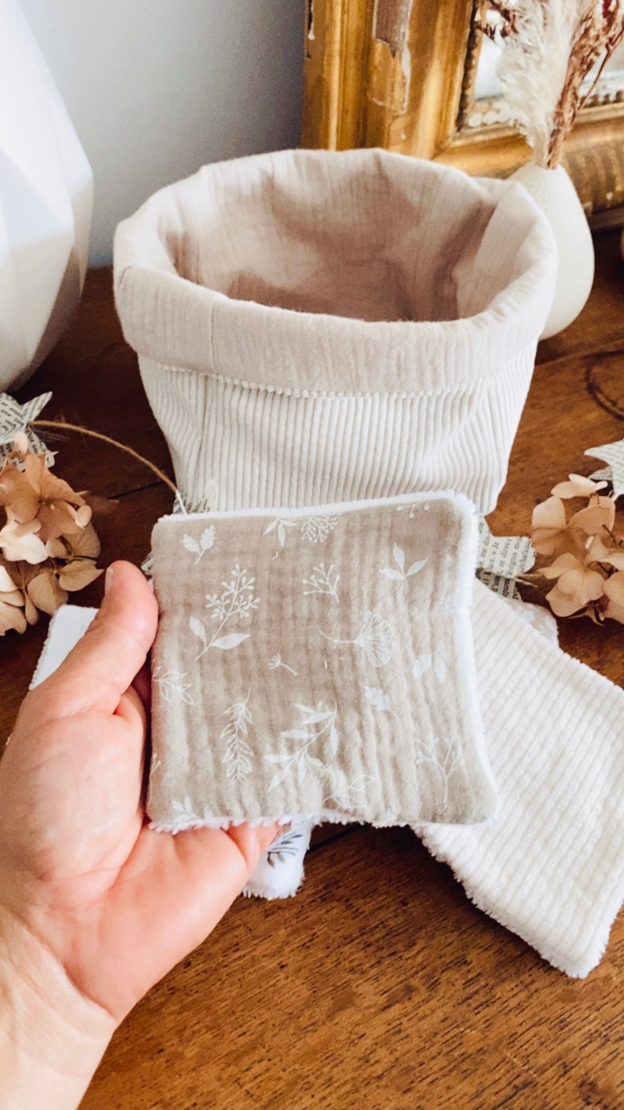 Ce coffret artisanal se compose d’une panière en tissu côtelé et de lingettes lavables assorties, cousues à la main dans mon atelier en France. Douces, absorbantes et écologiques, ces lingettes remplacent les cotons jetables du quotidien. L’ensemble s’intègre harmonieusement dans une salle de bain naturelle et élégante. ninona