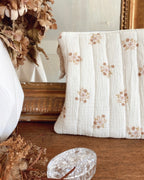 Élégante pochette fleurie réalisée à la main en tissu coton matelassé. Sa couleur écrue rehaussée de motifs floraux beiges en fait un accessoire romantique et intemporel. Utilisable comme trousse de maquillage, pochette de sac ou mini sac de soirée. Idée cadeau originale pour femme, pratique et unique, fabriquée avec soin en France. Un bel accessoire artisanal qui allie douceur, qualité et authenticité. création originale Ninona