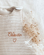 La gigoteuse bébé Ninona est une création artisanale française en nid d’abeille et double gaze de coton beige. Douce et respirante, elle remplace la couverture en toute sécurité. Personnalisable avec une broderie au prénom, cette gigoteuse personnalisée est un cadeau de naissance original et précieux. Ninona s’engage à proposer des gigoteuses bébé uniques, conçues à la main, pour allier confort, qualité et élégance.