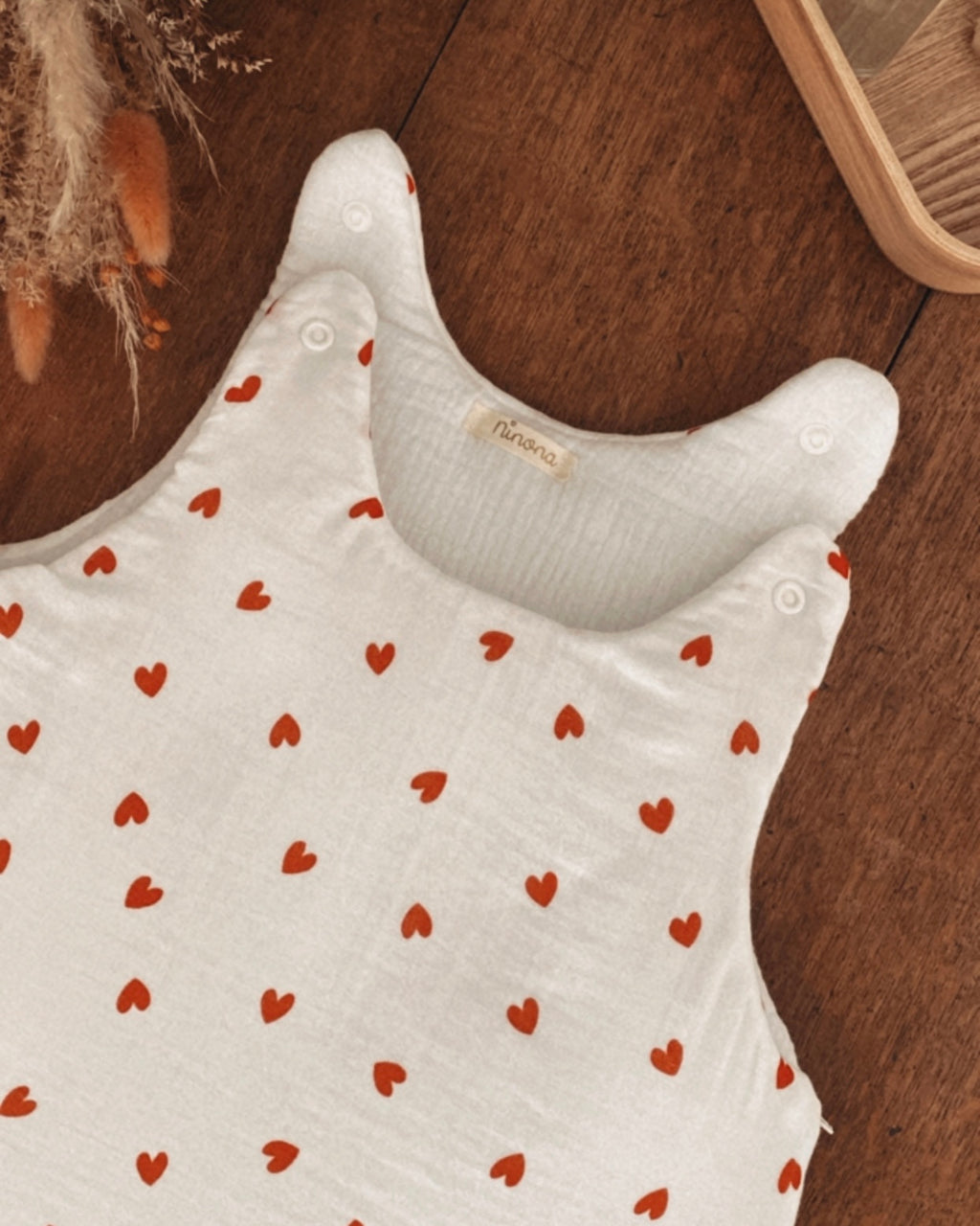 La gigoteuse Ninona en coton double gaze blanche à cœurs rouges allie douceur et tendance. Confectionnée à la main en France, elle offre chaleur et sécurité pour le sommeil de bébé. Un article cocooning artisanal qui devient aussi un bel élément de décoration dans la chambre de bébé.